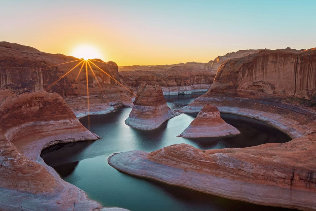 Image of the sunrise at Lake Powell in the Utah desert, USA with a river crossing in between rock mountains