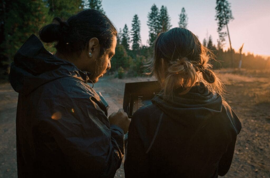 A man and woman review photos on their camera