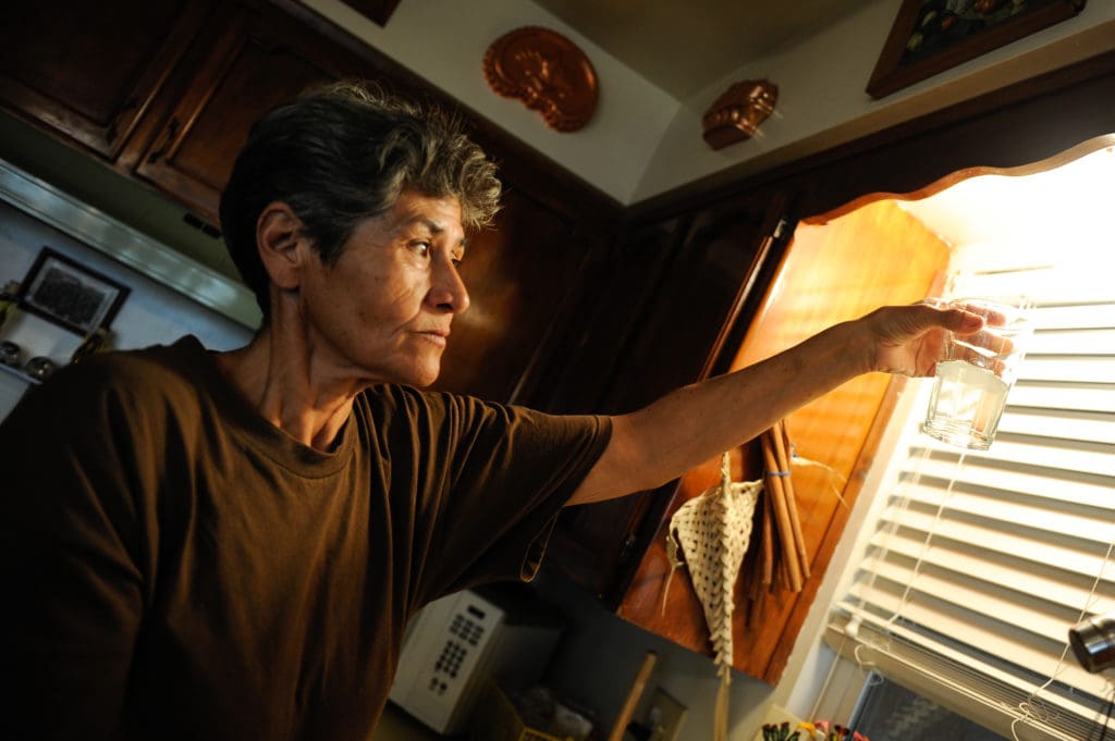 Photo of a woman looking at contaminated water..