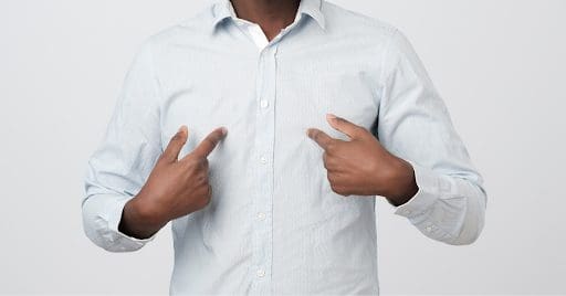 Stock image of a man pointing at himself with both hands.