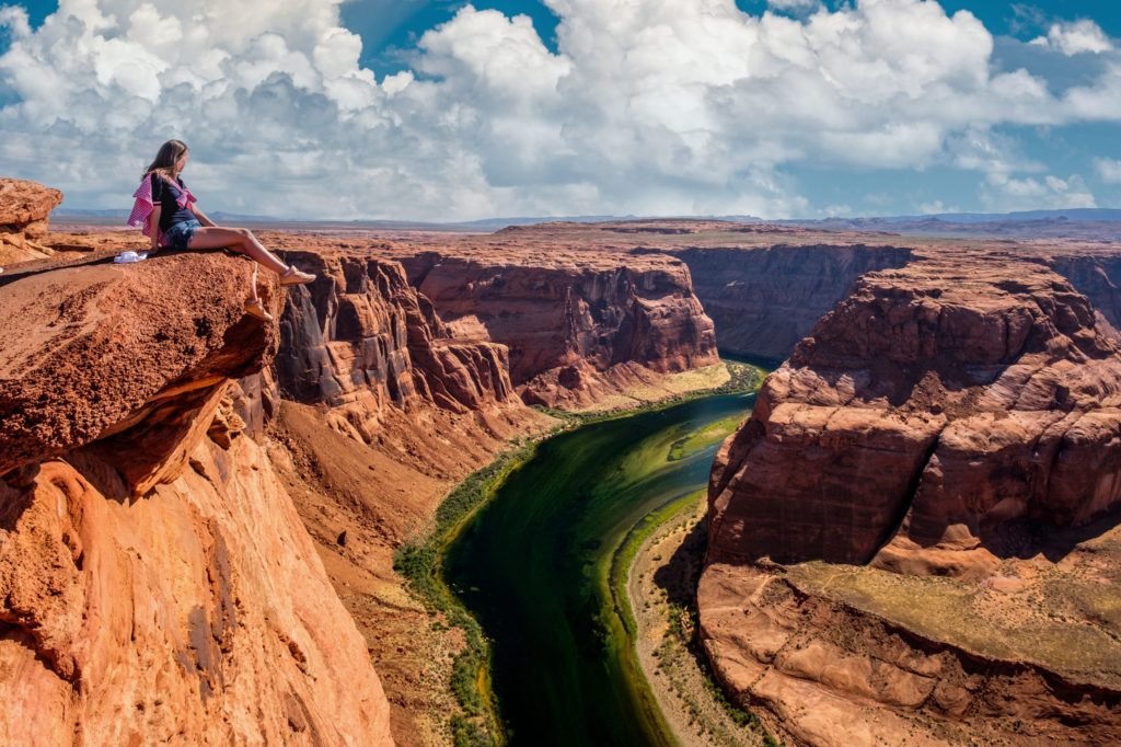 Tourist at Horseshoe Bend on Colorado River in Glen Canyon, Arizona, USA