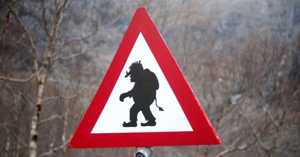 Photograph of a triangle shaped warning sign with red edges and outline of a troll in the middle.