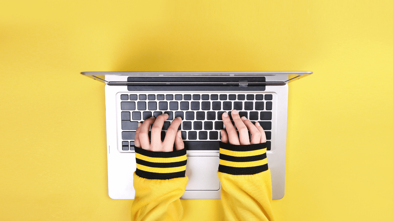 Stock image of a woman typing on a computer with both hands.