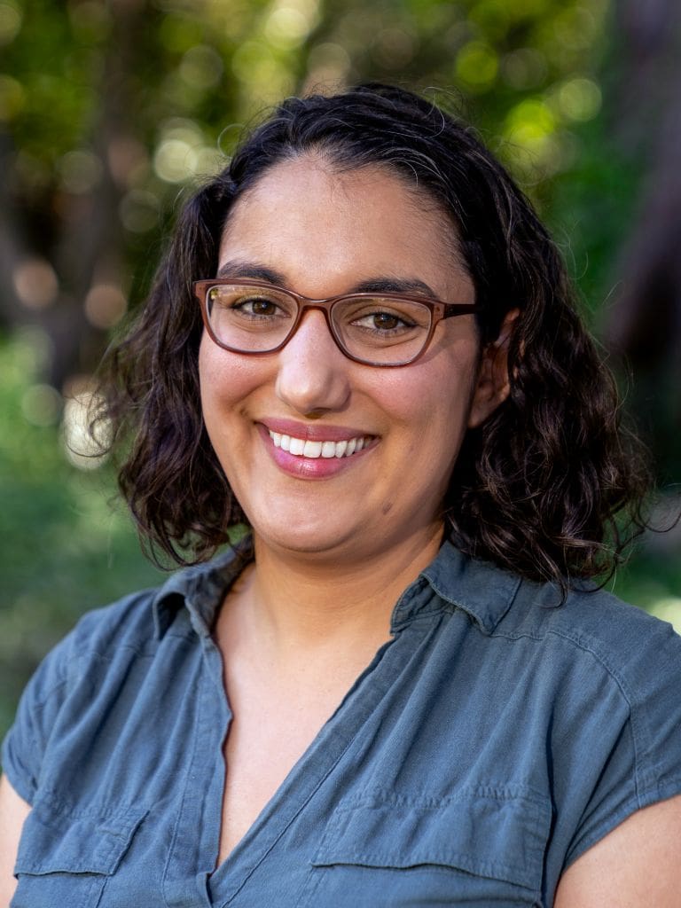 Headshot of Briana Flin smiling to camera wearing glasses outside