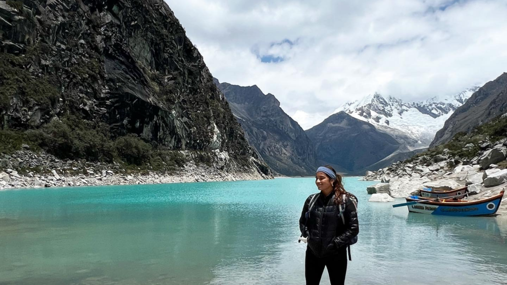 An image of Sussan standing in front of a laguna in the Andes mountains