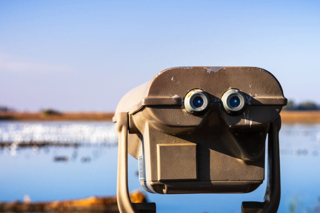 Photograph of an outdoor daytime viewing telescope looking over wetlands.