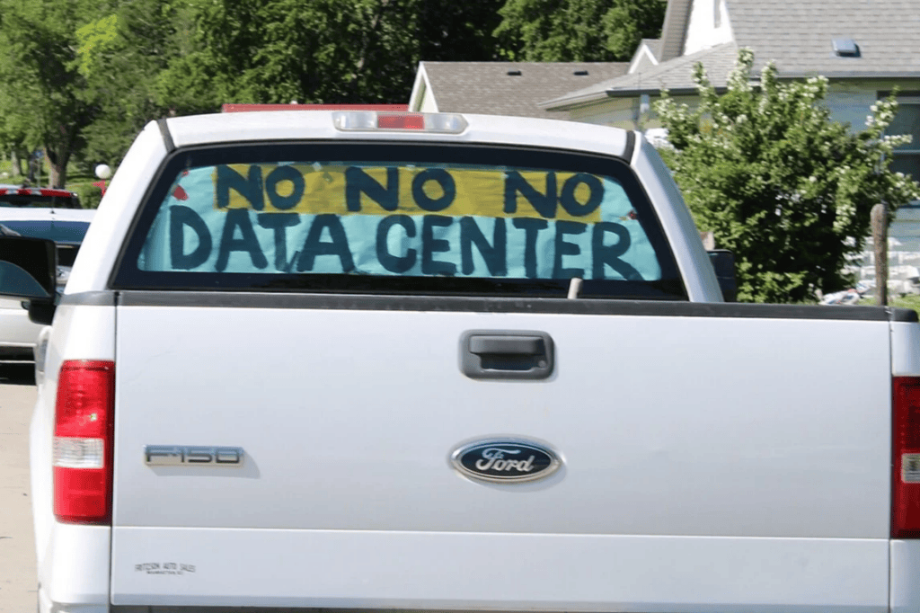 A truck with a sign with anti-data-center sentiment in rural Kansas neighborhood